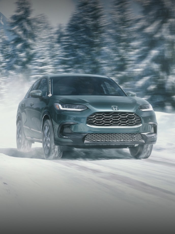 2027 Honda HR-V EX-L in Nordic Forest Pearl front view driving on a snowy road (Subcompact Crossover SUV).