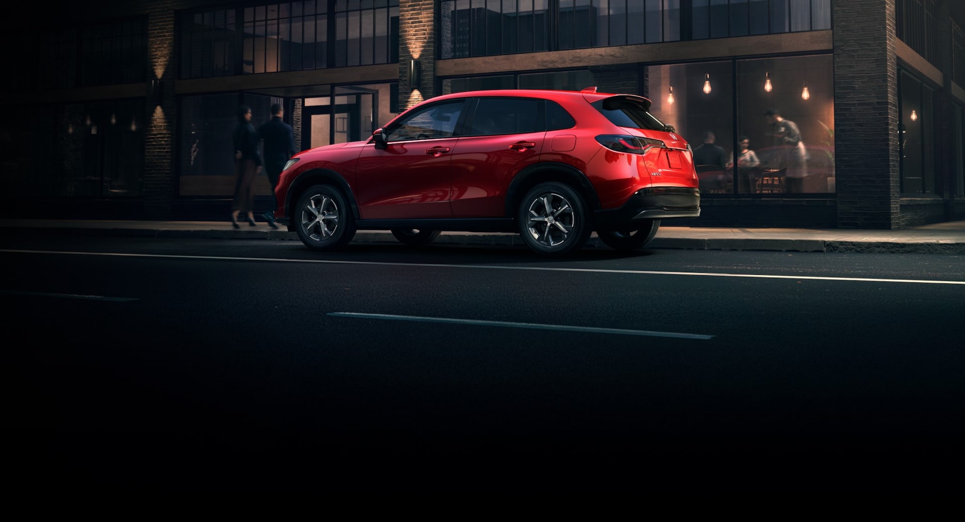 2025 Honda HR-V in Milano Red driving in the city, side view