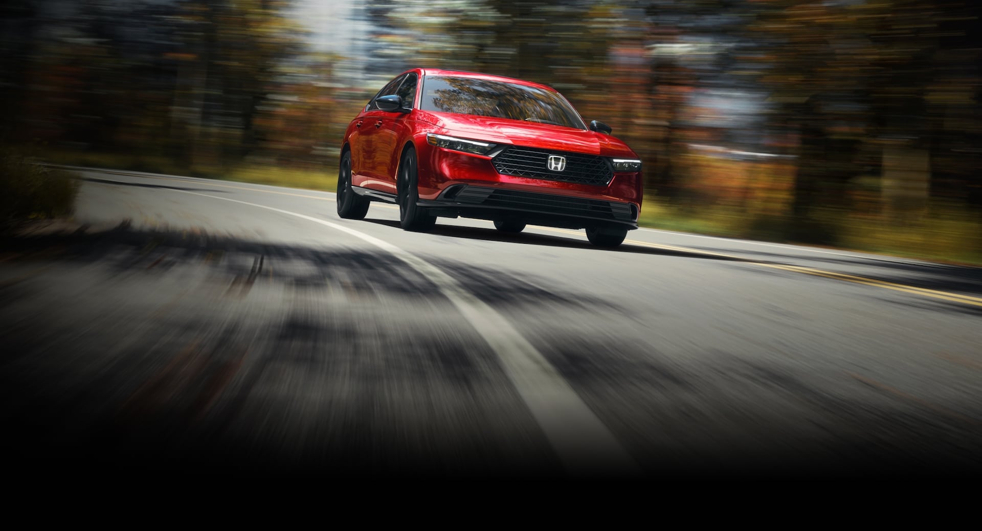 2026 Honda Accord driving in a forest environment taking the curve of the road.