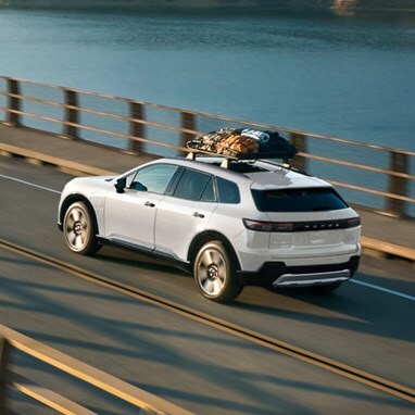 2026 Honda Prologue Elite in Frostline White Pearl crossing a bridge in afternoon light, featuring Honda Genuine Accessories.