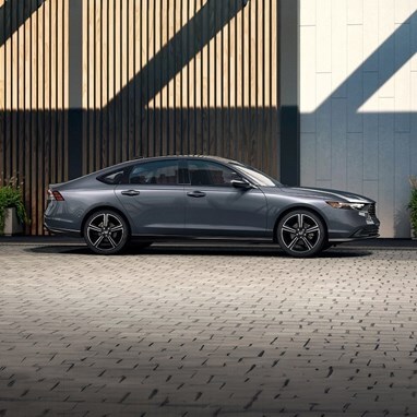 Profile view of 2026 Honda Accord parked against the rooftop structure of the parking garage.