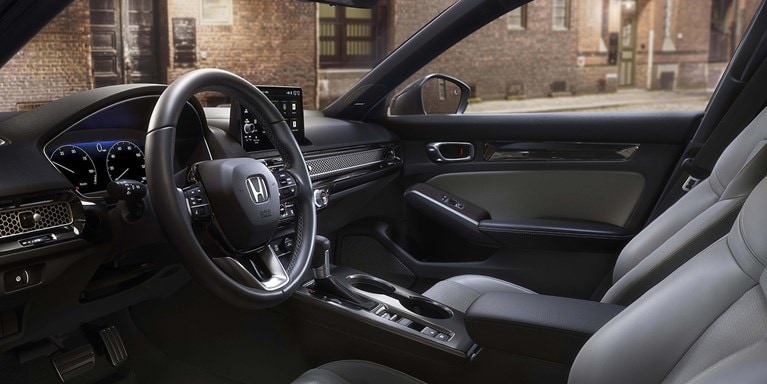 2026 Honda Civic Hatchback Touring Hybrid front cabin with leather-trimmed seats and dashboard (Compact Hatchback).