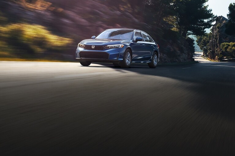 2026 Honda Civic LX in Blue Lagoon Pearl driving on a winding road (Compact Sedan)