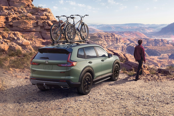 2026 Honda CR-V in Ash Green Metallic back desert canyon with bikes on roof (Compact Crossover SUV).